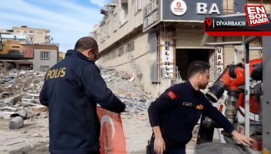 Depremin vurduğu Diyarbakır'da hasarlı evlerinden çıkan çift, binaya Türk bayrağı astı