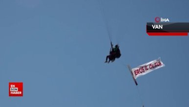 Yamaç paraşütü pilotu baba ve oğlu Erciş il olsun pankartı açtı