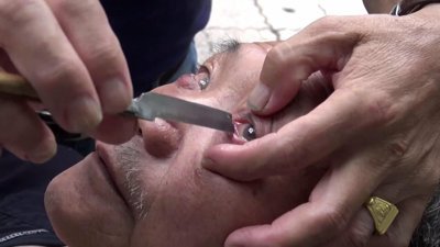 Ustura ile göz temizleyen berber