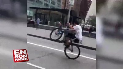 Tek teker üzerinde makas atan bisikletli
