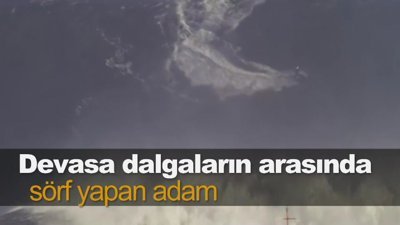 Devasa dalgaların arasında sörf yapan adam