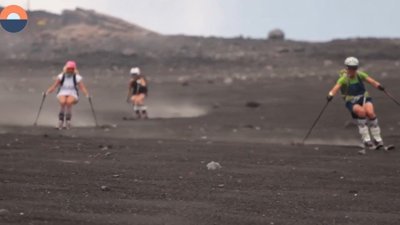 Etna Dağı'nın siyah yamaçlarında kum kayağı yapan üç kadın
