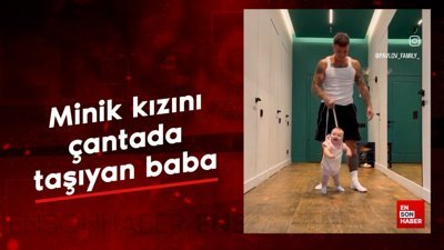 Minik kızını çantada taşıyan baba