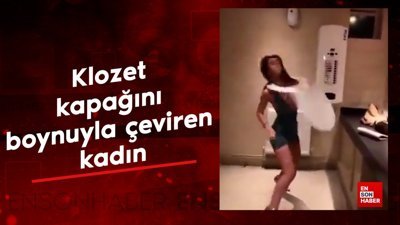 Klozet kapağını boynuyla çeviren kadın