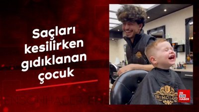 Saçları kesilirken gıdıklanan çocuk