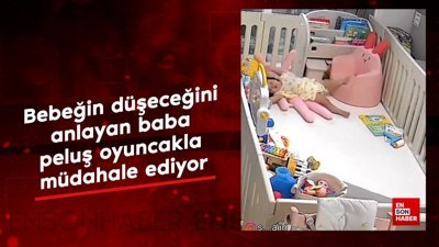 Bebeğin düşeceğini anlayan baba, peluş oyuncakla müdahale ediyor