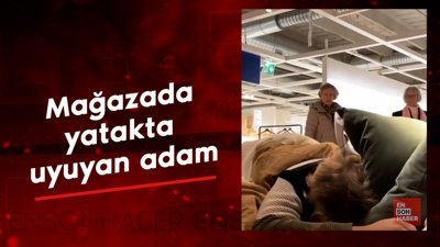 Mağazada yatakta uyuyan adam