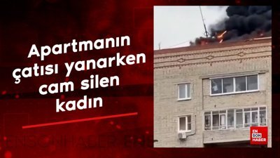 Apartmanın çatısı yanarken cam silen kadın