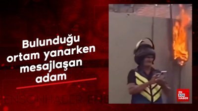 Bulunduğu ortam yanarken mesajlaşan adam