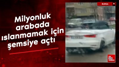 Bursa'da milyonluk arabada ıslanmamak için şemsiye açtı