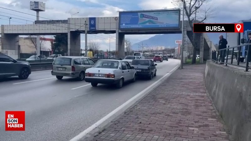 Bursa'da otomobilin kaputuna yatan kişinin ayaklarıyla öndeki aracı ittiği anlar