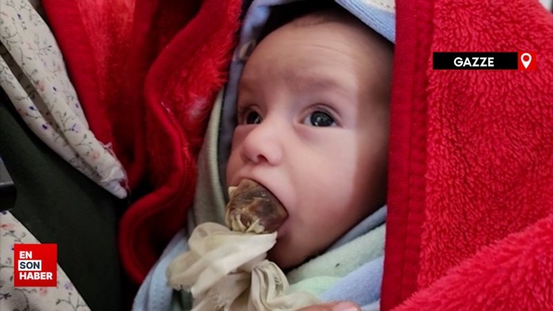 Gazzeli anne acıkan bebeğini susturabilmek için ona hurma ezmesi veriyor